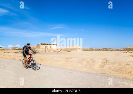 Man radelt in den Bardenas Reales ein von der spanischen UNESCO zum UNESCO gehörender, halbarder natürlicher Wüstenpark mit einer Mondlandschaft in der Region Navarra im Norden Spaniens Stockfoto