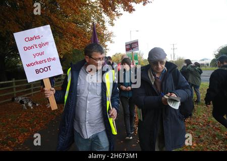 Street, Somerset, Großbritannien, 13. November 2021: Hunderte von Mitarbeitern solidarisierten sich mit etwa 150 Clarks Shoes, die ein Feuer anstellen und die Situation zu viel weniger günstigen Konditionen wieder in die Höhe ziehen. Einige arbeiten dort seit vierzig Jahren.Agenturmitarbeiter werden eingezogen, um streikende Arbeiter zu decken, die bessere Bezahlung erhalten. Der Streik geht weiter. Kredit: Natasha Quarmby/Alamy Live Nachrichten Stockfoto