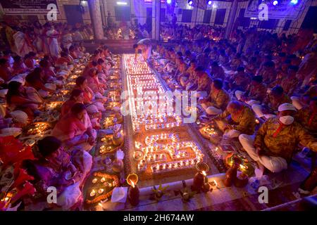 Dhaka. November 2021. Hinduistische Anhänger sitzen zum Gebet mit brennendem Weihrauch und Öllampen während des Rakher Upobash, einem religiösen Fastenfest, am 13. November 2021 in einem Tempel in Dhaka, Bangladesch. Quelle: Xinhua/Alamy Live News Stockfoto