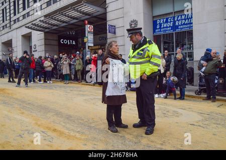 London, Großbritannien. November 2021. Ein Polizeibeamter versucht, einen mitten auf der Straße stehenden Protestierenden zu bewegen. Die Demonstranten der Extinction Rebellion marschierten durch die City of London und störten die Lord Mayor's Show aus Protest gegen das „Scheitern“ der COP26. Stockfoto