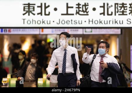 Tokio, Japan. Oktober 2021. Männer mit Gesichtsmasken gehen gemeinsam durch eine Eingangshalle am Bahnhof Tokio. Kredit: SOPA Images Limited/Alamy Live Nachrichten Stockfoto