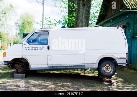 Altes rostiges Autorad. Gerissene Reifen und verrostete Radkappen. Stockfoto