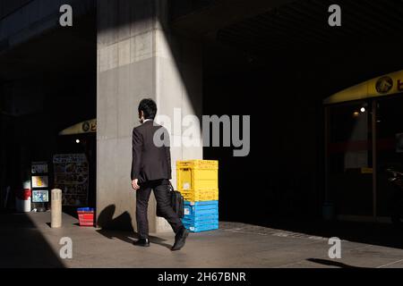 Tokio, Japan. Oktober 2021. Ein Geschäftsmann mit einem Koffer geht an Restaurants in der Nähe des Bahnhofs Tokyo vorbei. (Bild: © Stanislav Kogiku/SOPA Images via ZUMA Press Wire) Stockfoto