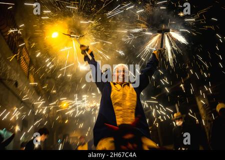 Barcelona, Spanien. November 2021. Feuerläufer der 'Diabolica de Gracia' tanzen zu traditionellen Trommeln unter ihrem funkelnden Feuerwerk durch die Straßen des Viertels Gracia in Barcelona, um ihr 39-jähriges Bestehen zu feiern.Quelle: Matthias Oesterle/Alamy Live News Stockfoto