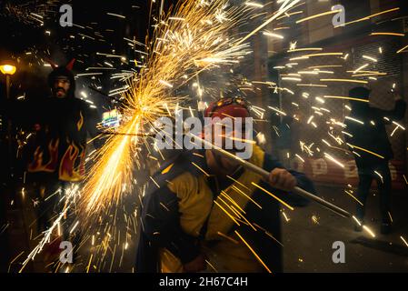 Barcelona, Spanien. November 2021. Feuerläufer der 'Diabolica de Gracia' tanzen zu traditionellen Trommeln unter ihrem funkelnden Feuerwerk durch die Straßen des Viertels Gracia in Barcelona, um ihr 39-jähriges Bestehen zu feiern.Quelle: Matthias Oesterle/Alamy Live News Stockfoto