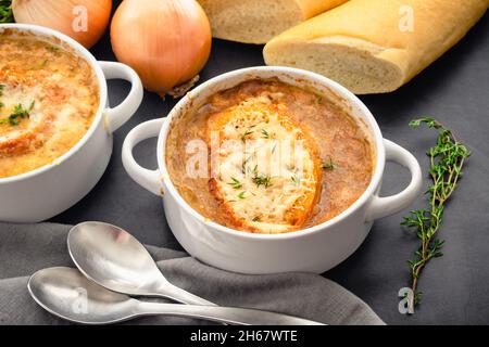 Schüsseln mit französischer Zwiebelsuppe mit geröstetem Brot und geriebenem Käse: Schüsseln mit französischer Zwiebelsuppe auf einer Pfanne Stockfoto