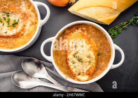 Schüsseln mit französischer Zwiebelsuppe mit geröstetem Brot und geriebenem Käse: Schüsseln mit französischer Zwiebelsuppe auf einer Pfanne Stockfoto