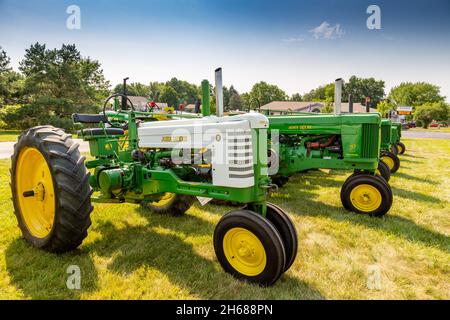 Ein Modell B und ein Modell 70 führen auf einer Traktorenschau in Warren, Indiana, USA, eine Reihe antiker John Deere Farmtraktoren an. Stockfoto
