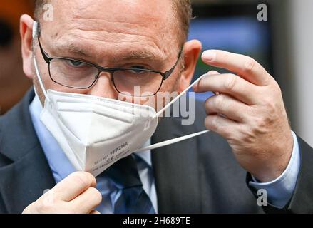 Potsdam, Deutschland. November 2021. Frank Werneke zieht eine FFP2-Maske am Rande einer Veranstaltung an. Der Chef von Verdi hat eine Korrektur der epidemischen Corona-Notlage gefordert, die von der werdenden Ampelkoalition ins Visier genommen wird. Quelle: Jens Kalaene/dpa-Zentralbild/dpa/Alamy Live News Stockfoto