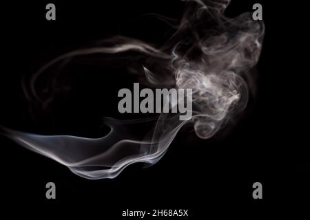 Abstrakte Rauchbewegung auf dunklem Hintergrund. Konzept des alternativen Nikotinrauchens. Verschwommenes Bild warmer, getönter Rauch. Elektronische Zigarette. Verdampfer. Weichfokus. Streaming. Stockfoto