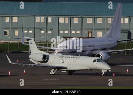 FAH-001, ein Embraer Legacy 600, das von der honduranischen Luftwaffe (Fuerza Aérea Hondureña - FAE) in einer VIP-Transportrolle auf dem Prestwick International Airport in Ayrshire, Schottland, betrieben wird. Gleich dahinter ist A6-RJU zu sehen, eine Boeing 737-77W(WL), die von Royal Jet betrieben und die angolanische Regierung gechartert hat. Das Flugzeug war in Schottland, um Delegierte zur COP26-Klimakonferenz im nahe gelegenen Glasgow zu bringen. Stockfoto