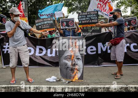 14. November 2021: Philippinische Aktivisten verbrennen ein Plakat mit Gesichtsbildern der Bürgermeisterin von Davao, Sara Duterte, und des Sohnes des verstorbenen Diktators Ferdinand Marcos, während eines Protestes gegen Regierungsbeamte, die ihre Kandidatur bei den nationalen Wahlen 2022 vor der Menschenrechtskommission in Quezon City eingereicht haben, Metro Manila, Philippinen. 14. November 2021. Die Tochter des philippinischen Präsidenten Rodrigo Duterte reichte am Samstag Papiere ein, um bei den Parlamentswahlen 2022 für den Vizepräsidenten zu kandidieren, was die Spekulationen beendete, dass sie das höchste Amt des Landes anstreben würde, aber den Sohn dazu veranlasste Stockfoto