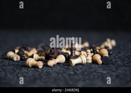 Verstreute Schachfiguren auf einem verschwommenen schwarzen Hintergrund. Stockfoto
