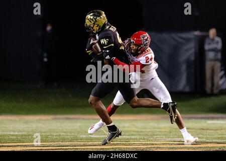 13. November 2021: Wake Forest Demon Diacons Wide Receiver A.T. Perry (9) holt sich den ersten Rückschlag, bevor er im dritten Quartal des ACC-Fußballmatches im Truist Field in Winston-Salem, NC, von Derrek Pitts Jr. (24), dem Eckpfeiler von North Carolina State Wolfpack, angegangen wird. (Scott Kinser/Cal Sport Media) Stockfoto