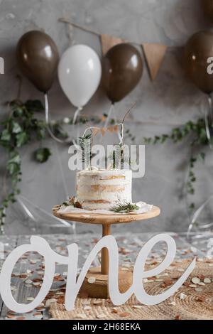 Baby ersten Geburtstag Dekorationen, ein Jahr alt, Hintergrund mit Kuchen und Luftballons, Holzbuchstaben ein, Minimalismus-Stil. Stockfoto