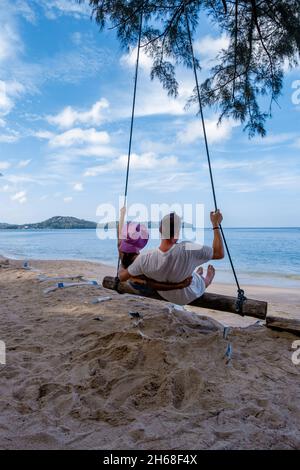 Bang Tao Beach Phuket Thailand, Strand mit Palmen und ein paar Männer und Frauen in der Schaukel am Strand. Sommer, Reisen, Urlaub und Urlaub Konzept - Swing hängt von Kokospalme Stockfoto