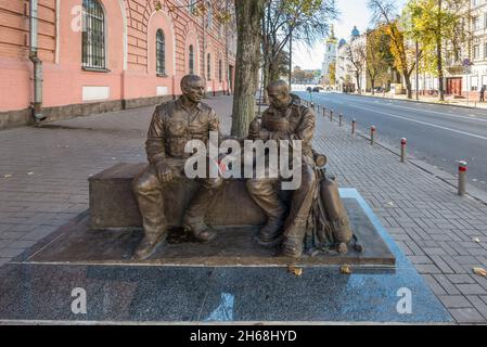 Kiew, Ukraine - 15. Oktober 2021: Müder Polizist und Retter teilen sich eine Flasche Wasser - Skulptur in Kiew in der Wladimirskaja Straße, 13. Bildhauer Vsev Stockfoto