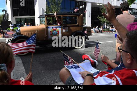 Orlando, Usa. November 2021. Während einer Veterans Day Parade in Orlando, Florida, winken Zuschauer US-amerikanische Flaggen. Kredit: SOPA Images Limited/Alamy Live Nachrichten Stockfoto