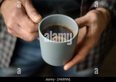 Tasse Kaffee in der Hand eines Mannes Stockfoto