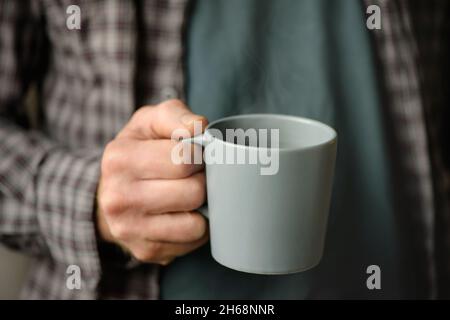 Tasse Kaffee in der Hand eines Mannes Stockfoto