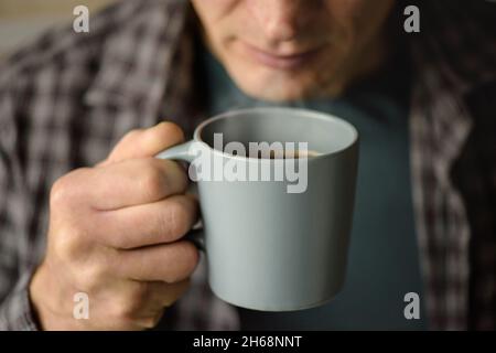 Tasse Kaffee in der Hand eines Mannes Stockfoto