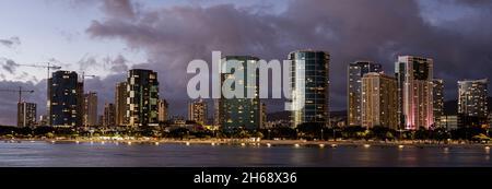 Waikiki, Honolulu, Hawaii - 31. Oktober 2021 - Skyline vom Strand nach Sonnenuntergang bei Dunkelheit. Stockfoto