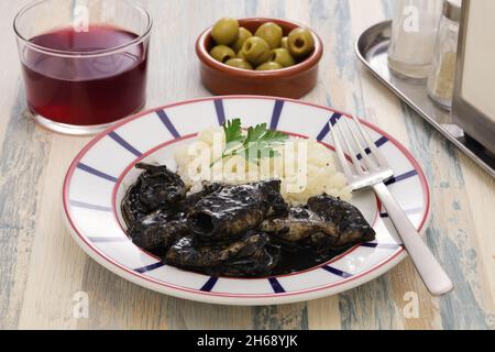 Chipirones en su tinta, kleiner Tintenfisch in schwarzer Tinte gekocht, spanische baskische Küche Stockfoto