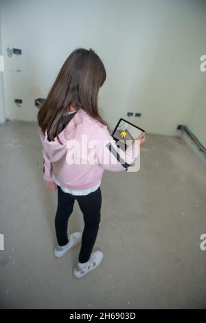 Junges Mädchen platzieren Objekt in Augmented Reality. Umzug in ein neues Zuhause Stockfoto