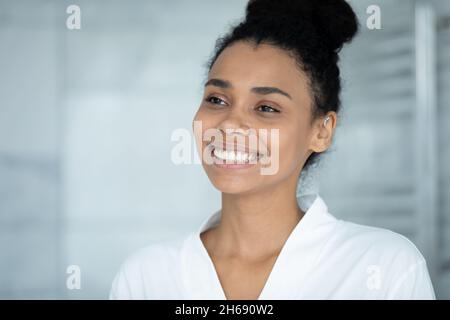 Lächelnde junge afrikanische Ethnie junge Frau, die in der Ferne schaut. Stockfoto