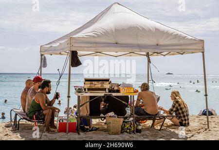 Waikiki, Honolulu, Hawaii - 31. Oktober 2021-Familie genießt ein Picknick unter ihrem eigenen Dach am Strand. Stockfoto