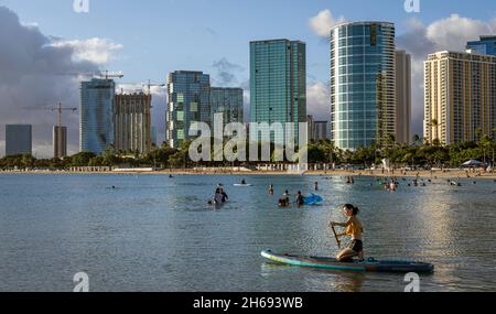 Honolulu, Hawaii - 6. November 2021 – vor den Waikiki-Hochhäusern in Honolulu, Hawaii, spielen Menschen im Wasser. Stockfoto