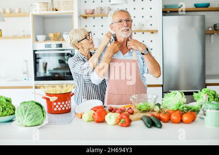 Liebe Küche Senior Frau Mann Paar Heim Ruhestand glückliches Essen lächelnd Mann Frau zusammen Person Stockfoto