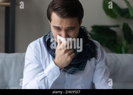 Ungesunder junger Mann, der an laufender Nase leidet. Stockfoto