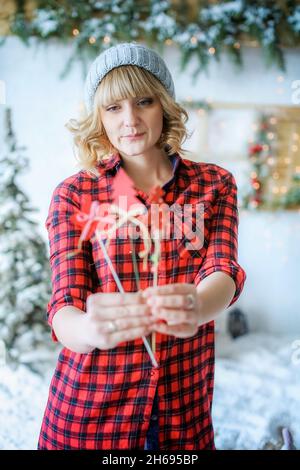 Nahaufnahme eines Modelmädchen auf dem Hintergrund der Winterlandschaft mit roten Herzen auf einem Stock in ihren Händen. Stockfoto