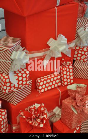 Rot-weiße und beribbonierte Geschenkschachteln im Stapel. Urlaub Seson Geschenke unter Weihnachtsbaum.Multicolored und beribboned Geschenk-Boxen in Haufen. Stockfoto