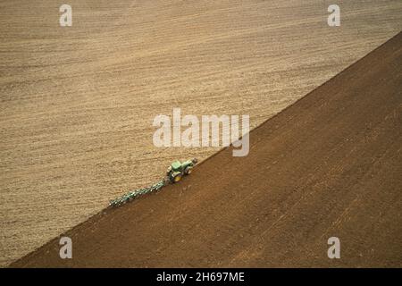 Der Traktor, der das Feld pflügt. Luftaufnahmen. Stockfoto
