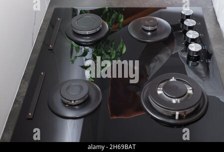 Reinigen Sie den glänzenden Gasherd mit Lappen Reflexion Stockfoto