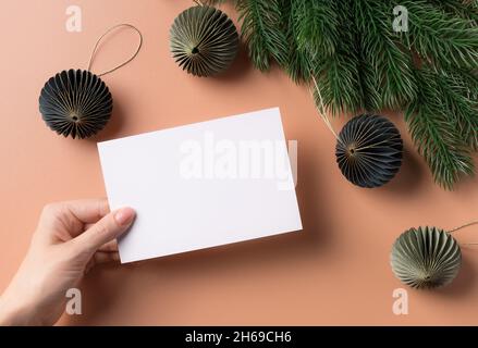 Mockup Weihnachten Grußkarte Brief in weiblicher Hand Stockfoto