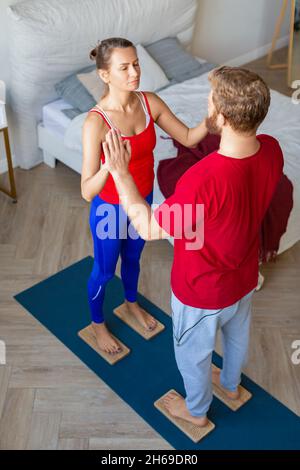Paar stehen auf Sahu-Brettern mit scharfen Nägeln. Yoga gemeinsam praktizieren und meditieren. Stockfoto