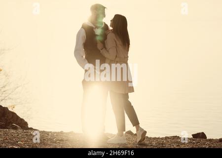 Liebende Paar Zu Fuß. Lifestyle-Foto in voller Größe von funky verträumten Liebhabern. Rückansicht des Paares gegen den See. Freeluft-Ästhetik. Lässiger Style Stockfoto
