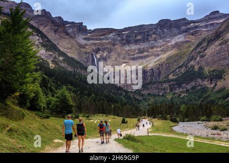 Wanderer wandern im Cirque de Gavarnie im Nationalpark der französischen Pyrenäen, der zum UNESCO-Weltkulturerbe gehört. Der Cirque wurde von einem Gletscher geformt. Stockfoto