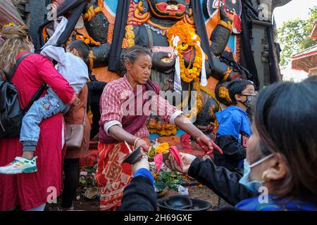 Kathmandu, Nepal - 2021. November: Pilger, die am 13. November 2021 in Kathmandu auf dem Durbar-Platz vor der Figur des Kala Bhairab Opfergaben, Stockfoto