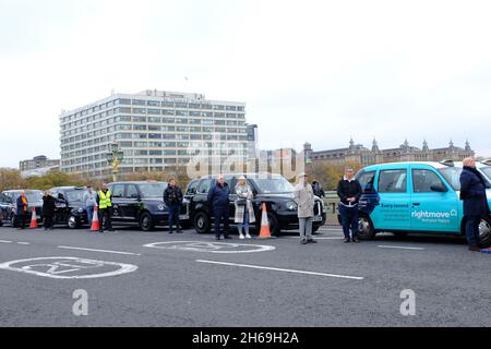 London, Großbritannien. November 2021. Dreihundert moderne und alte schwarze Taxis fahren am Remembrance Sunday auf der Länge der Westminster Bridge, um am jährlichen „Poppy Cabs“-Service teilzunehmen, der Veteranen kostenlose Fahrten zum Cenotaph-Gedenkgottesdienst in der Hauptstadt bietet. Schwarze Taxifahrer und Autoethnografen sind aus ganz London und dem Südosten angereist, um an einem seit 2009 laufenden Programm teilzunehmen. Kredit: Elfte Stunde Fotografie/Alamy Live Nachrichten Stockfoto