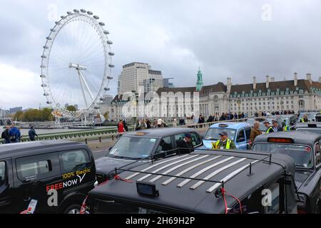 London, Großbritannien. Am 14. November 2021 fahren dreihundert moderne und alte schwarze Taxis am Remembrance Sunday entlang der Westminster Bridge und nehmen am jährlichen „Poppy Cabs“-Service Teil, der Veteranen, die am Cenotaph-Gedenkgottesdienst in der Hauptstadt teilnehmen, kostenlose Fahrten anbietet. Schwarze Taxifahrer und Autoethnografen sind aus ganz London und dem Südosten angereist, um an einem seit 2009 laufenden Programm teilzunehmen. Kredit: Elfte Stunde Fotografie/Alamy Live Nachrichten Stockfoto