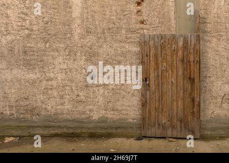 Alte Holztür vor einer schmutzigen Fassade Stockfoto