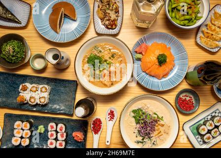 Japanisches Speiseteller, Hosomaki mit Lachs und rotem Thunfisch, Uramaki mit panierten Garnelen, mochis, Miso Ramen, Wakame-Salat, roter Pfeffer, Edamame Bohnen, oktop Stockfoto