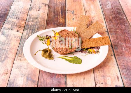 Das Steak ist ein Gericht aus rohem Hackfleisch. Es wird in der Regel mit fein gehackten Zwiebeln, Kapern und verschiedenen Zutaten, manchmal ein Eigelb i serviert Stockfoto