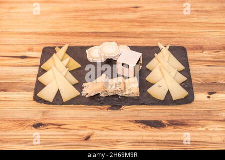 Große Tabelle mit verschiedenen Käsesorten als Tapas oder als Aperitif auf einem Holztisch zu nehmen Stockfoto
