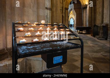 Votiv- oder Gebetskerzenständer mit Opferbox in der Chichester Cathedral in Chichester, Großbritannien. Mit Dank an den Dekan und das Kapitel der Chichester Kathedrale. Stockfoto