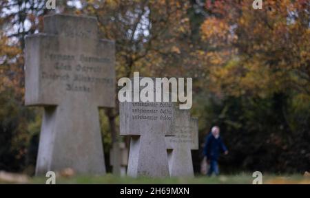 Magdeburg, Deutschland. November 2021. Eine Frau geht an einem Grab mit der Aufschrift '1945 Unbekannter Soldat' auf einem Militärfriedhof auf dem Westfriedhof in Magdeburg vorbei. Am Gedenktag wurden die Opfer von Krieg und Tyrannei in ganz Sachsen-Anhalt mit Kranzniederlegungen und Gottesdiensten gedenkt. Quelle: Ronny Hartmann/dpa/Alamy Live News Stockfoto